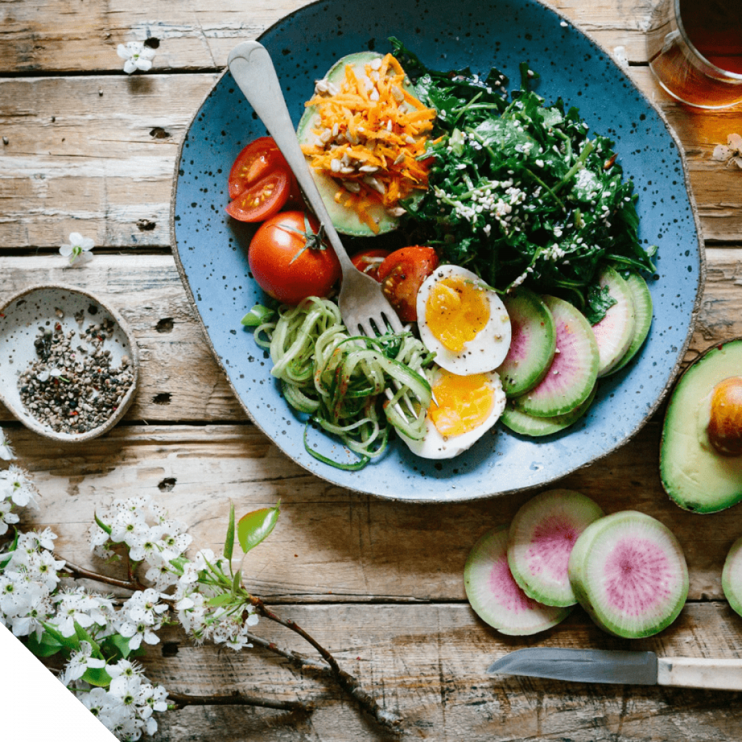 Gezonde ingrediënten als avocado en spinazie op blauw bord | Recover Health